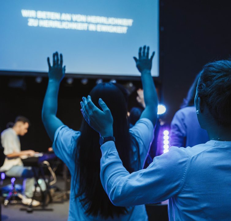 Woman at the Worshippen and holding her hands upwards