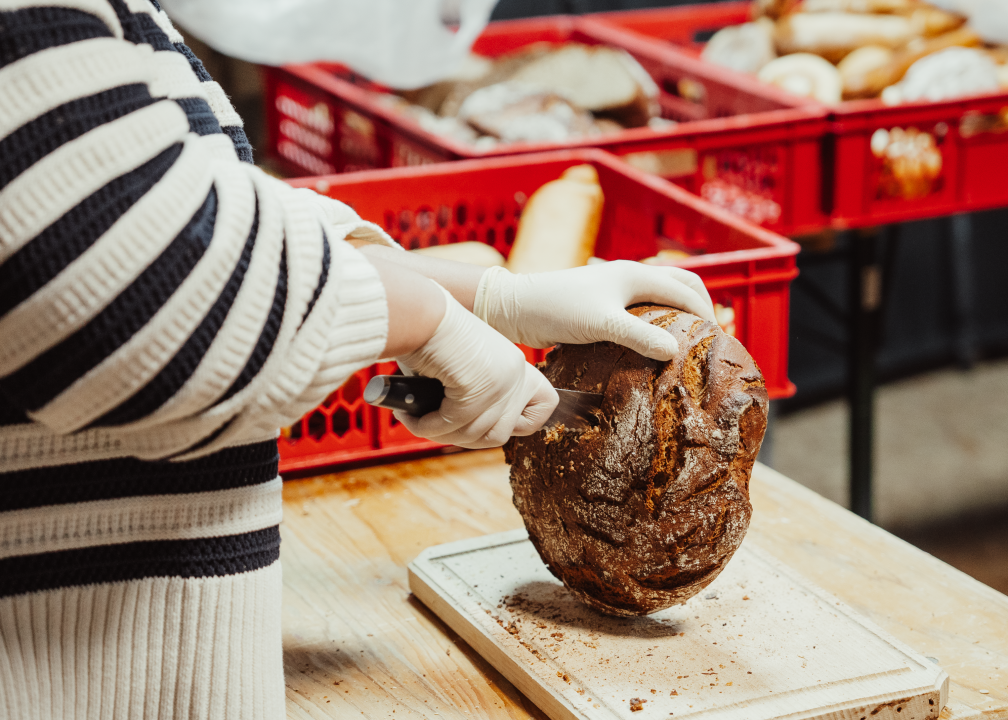 Someone cuts bread